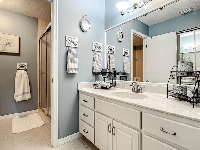bathroom with visible vents, tile patterned flooring, vanity, baseboards, and a stall shower