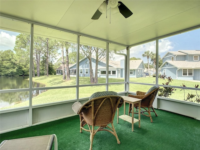 sunroom / solarium featuring a water view, ceiling fan, and a residential view