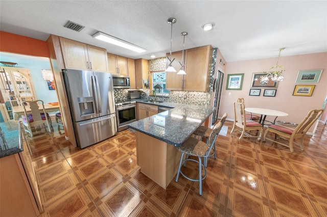 4350 Candlewood Ln, Ponce Inlet, FL 32127 - kitchen featuring visible vents, appliances with stainless steel finishes, tasteful backsplash, a peninsula, and dark stone countertops