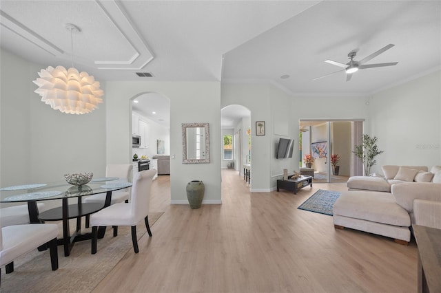 11222 Rapallo Ln, Windermere, FL 34786 - living room with arched walkways, light wood finished floors, a ceiling fan, crown molding, and baseboards