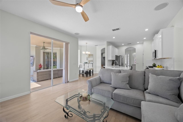 11222 Rapallo Ln, Windermere, FL 34786 - living room featuring a ceiling fan, arched walkways, light wood-style flooring, baseboards, and recessed lighting