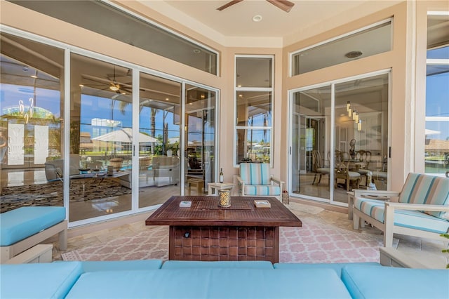 sunroom / solarium featuring a ceiling fan and an outdoor living space
