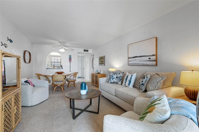 carpeted living room featuring a ceiling fan and visible vents