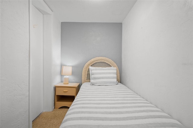 bedroom with carpet and a textured wall