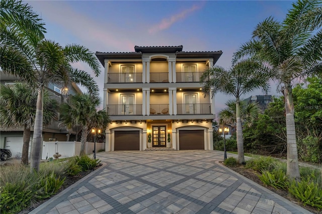 6771 Turtlemound Rd, New Smyrna Beach, FL 32169 - view of front of home with fence, an attached garage, driveway, a balcony, and stucco siding