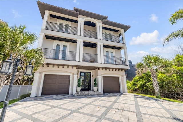 6771 Turtlemound Rd, New Smyrna Beach, FL 32169 - view of front of home featuring a balcony, french doors, fence, an attached garage, and stucco siding