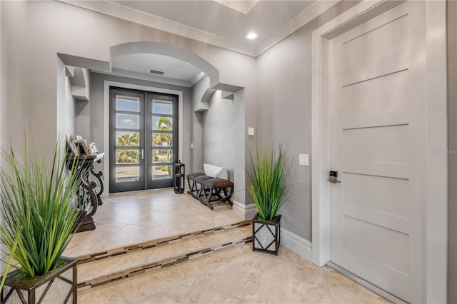 6771 Turtlemound Rd, New Smyrna Beach, FL 32169 - foyer entrance featuring french doors, baseboards, marble finish floor, ornamental molding, and arched walkways