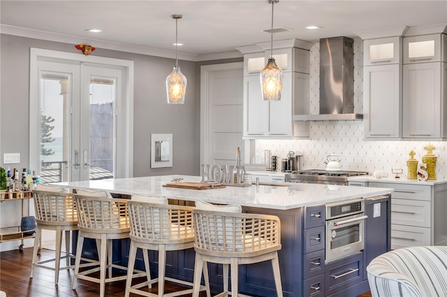 6771 Turtlemound Rd, New Smyrna Beach, FL 32169 - kitchen with a breakfast bar, wall chimney exhaust hood, a center island with sink, backsplash, and stainless steel oven