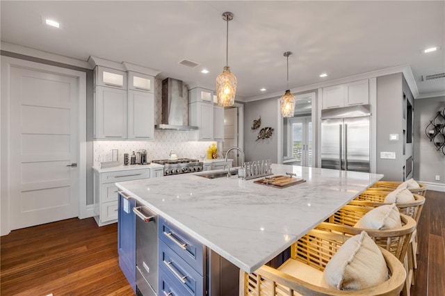 6771 Turtlemound Rd, New Smyrna Beach, FL 32169 - kitchen featuring a sink, wall chimney range hood, dark wood-type flooring, visible vents, and stainless steel built in fridge