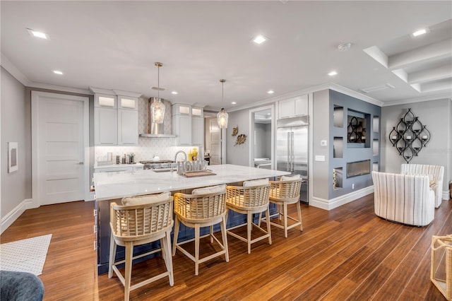 6771 Turtlemound Rd, New Smyrna Beach, FL 32169 - kitchen with wall chimney range hood, ornamental molding, a kitchen island with sink, decorative backsplash, and built in fridge
