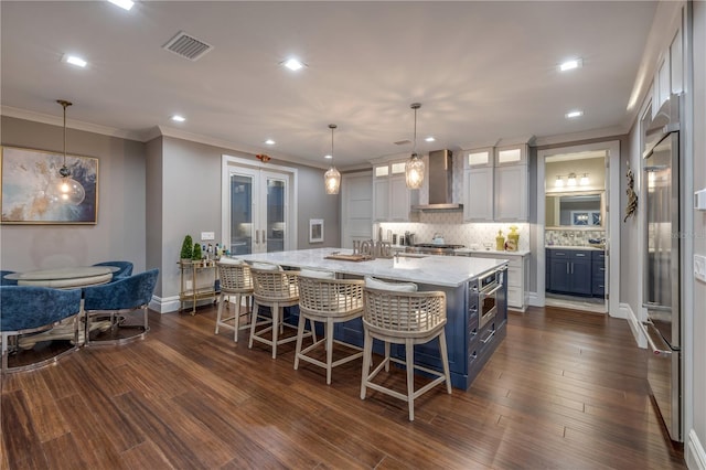 6771 Turtlemound Rd, New Smyrna Beach, FL 32169 - kitchen featuring light stone counters, visible vents, backsplash, wall chimney range hood, and a large island