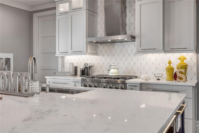 6771 Turtlemound Rd, New Smyrna Beach, FL 32169 - kitchen featuring light stone countertops, range, glass insert cabinets, decorative backsplash, and wall chimney exhaust hood
