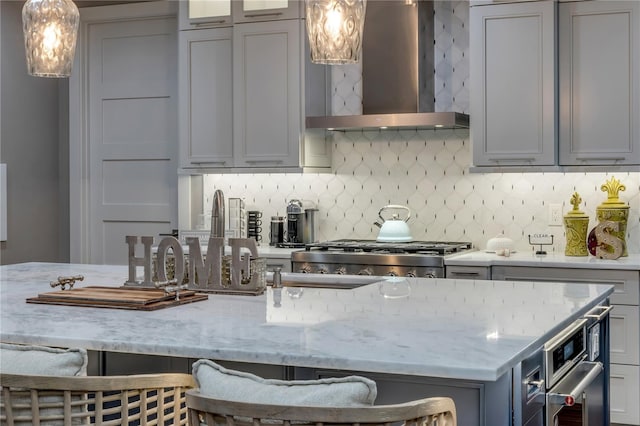6771 Turtlemound Rd, New Smyrna Beach, FL 32169 - kitchen featuring tasteful backsplash, decorative light fixtures, wall chimney exhaust hood, stove, and light stone countertops