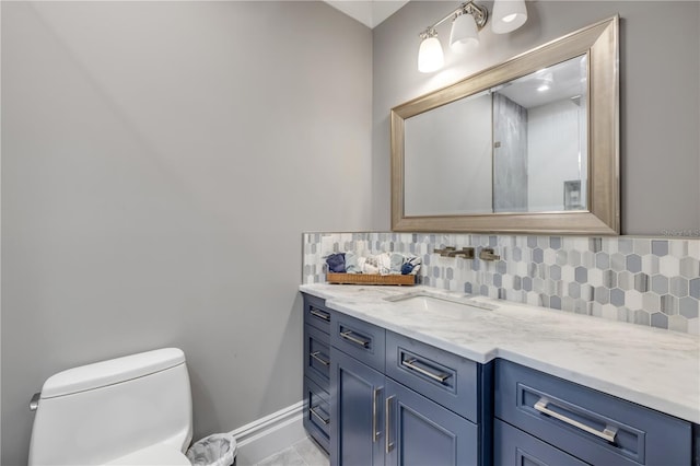 6771 Turtlemound Rd, New Smyrna Beach, FL 32169 - bathroom with vanity, toilet, decorative backsplash, and baseboards