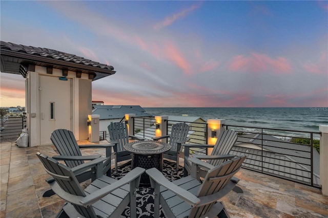 6771 Turtlemound Rd, New Smyrna Beach, FL 32169 - patio terrace at dusk with an outdoor fire pit and a water view