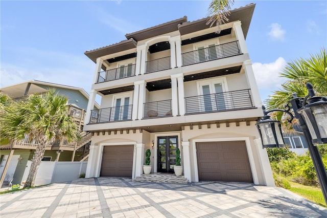 6771 Turtlemound Rd, New Smyrna Beach, FL 32169 - view of front of home featuring fence, an attached garage, french doors, driveway, and a balcony