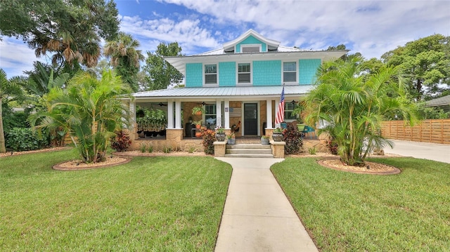 508 Faulkner St, New Smyrna Beach, FL 32168 - view of front of property with a porch, concrete driveway, a ceiling fan, and metal roof