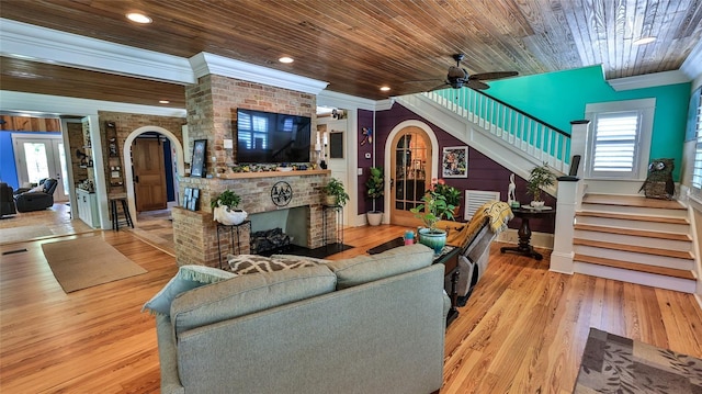 508 Faulkner St, New Smyrna Beach, FL 32168 - living room featuring arched walkways, stairs, crown molding, a fireplace, and wood finished floors