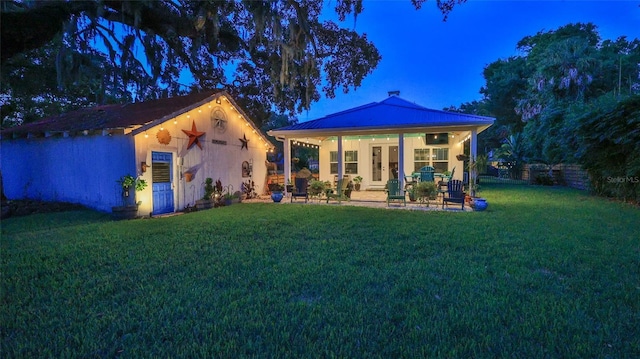 508 Faulkner St, New Smyrna Beach, FL 32168 - view of front of property with a lawn, french doors, metal roof, a patio, and a standing seam roof
