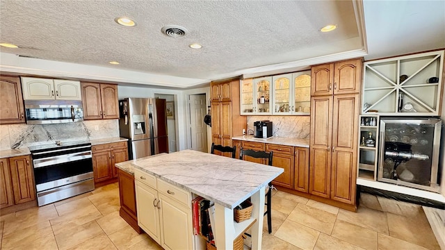 34 Richmond Dr, New Smyrna Beach, FL 32169 - kitchen with backsplash, a textured ceiling, appliances with stainless steel finishes, and wine cooler