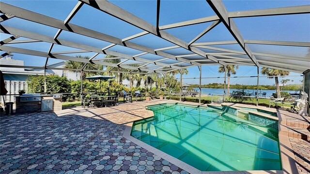34 Richmond Dr, New Smyrna Beach, FL 32169 - view of swimming pool featuring a water view, a patio, exterior kitchen, and a lanai