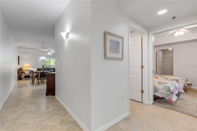 hall featuring baseboards and light tile patterned floors