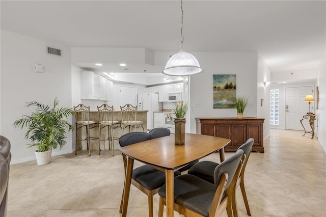 dining space featuring light tile patterned flooring, baseboards, and recessed lighting