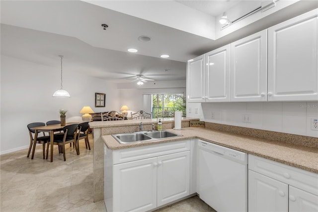 kitchen featuring dishwasher, a sink, a peninsula, white cabinets, and recessed lighting
