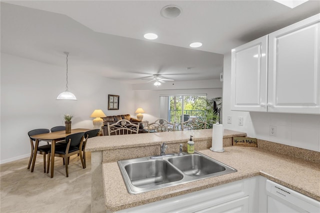 kitchen featuring dishwasher, a sink, white cabinets, a peninsula, and hanging light fixtures