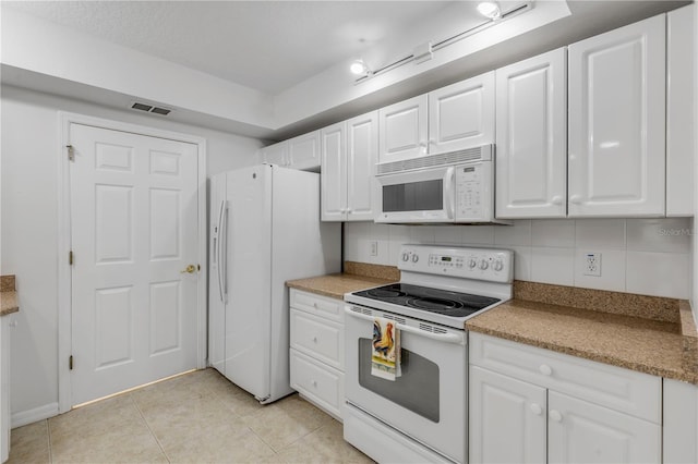 kitchen with white appliances, white cabinetry, backsplash, and light tile patterned floors