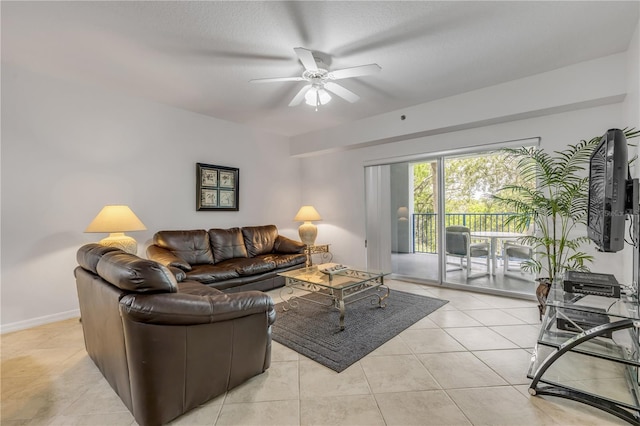 living room with ceiling fan, light tile patterned floors, and baseboards