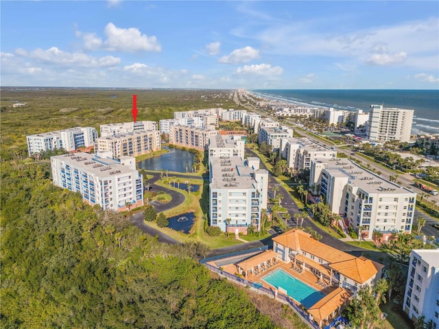 view of urban area with a pool area, a nearby body of water, and apartment complex