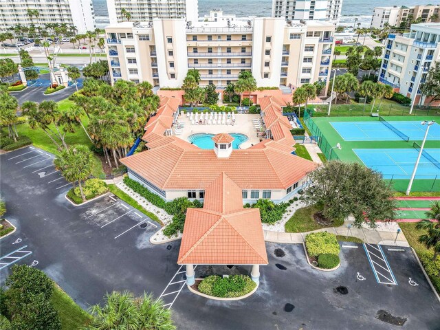 drone / aerial view of a pool and a nearby body of water