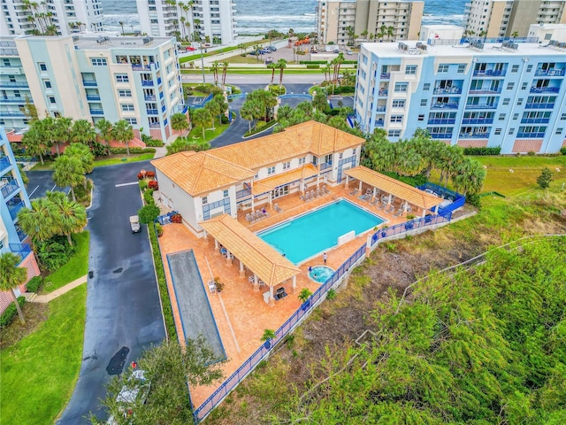 view of urban area featuring a pool area, apartment complex / building, and a nearby body of water