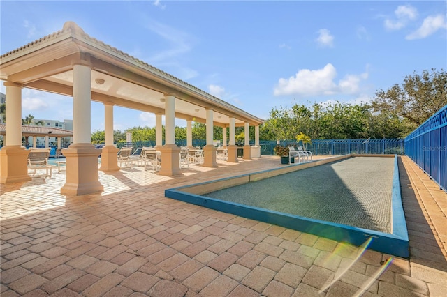 view of property's community with a bocce ball area and fence