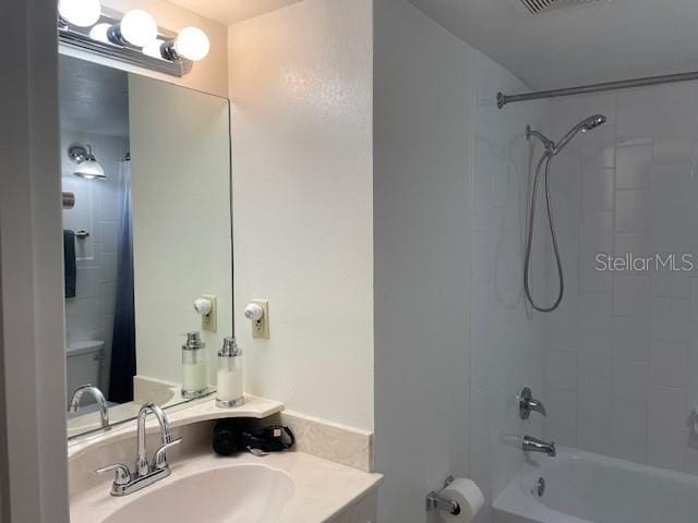 bathroom featuring toilet,  shower combination, vanity, and visible vents