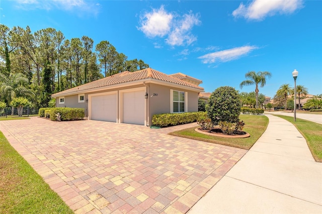 view of home's exterior with a garage, a tiled roof, stucco siding, fence, and decorative driveway