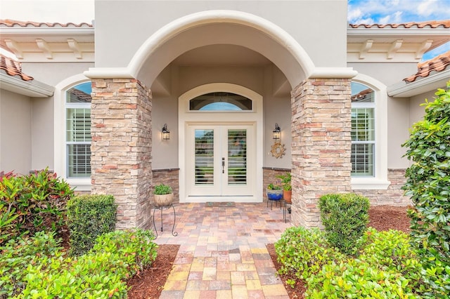 property entrance featuring stucco siding and french doors