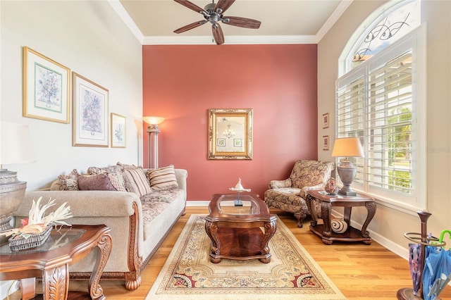 sitting room with light wood finished floors, crown molding, baseboards, and ceiling fan