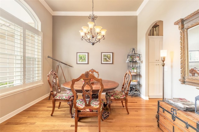dining space featuring light wood-type flooring, a chandelier, baseboards, and ornamental molding