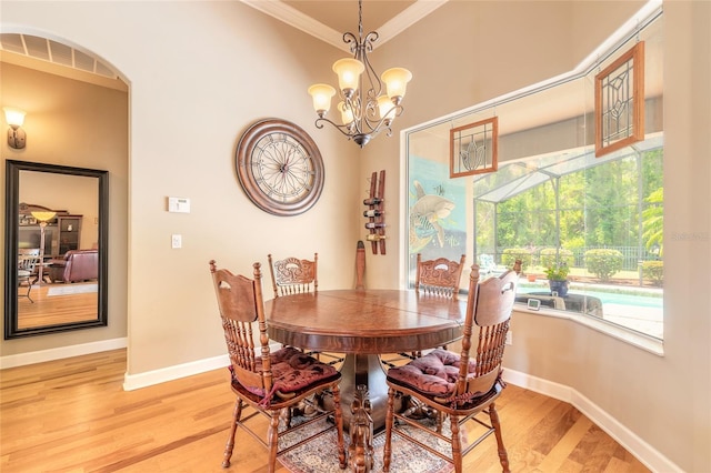 dining room featuring light wood finished floors, crown molding, visible vents, baseboards, and a chandelier