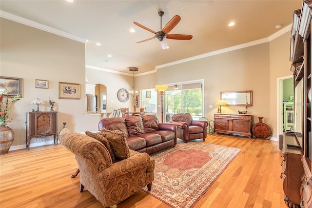 living area with recessed lighting, crown molding, arched walkways, a ceiling fan, and light wood-style floors