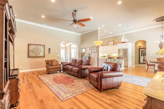 living area featuring ceiling fan, light wood finished floors, arched walkways, and recessed lighting