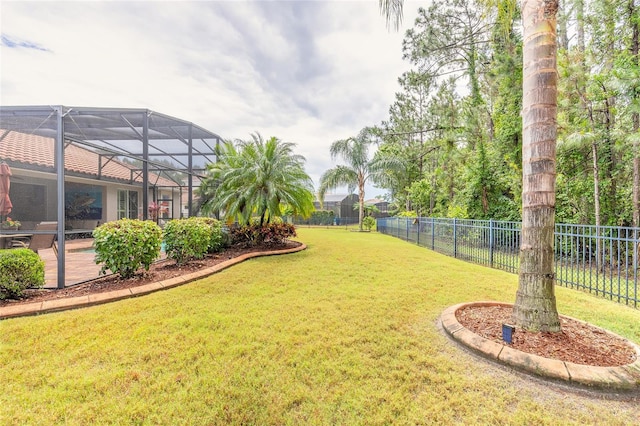 view of yard with glass enclosure and fence