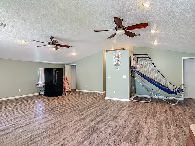 unfurnished living room featuring a textured ceiling, a ceiling fan, wood finished floors, and lofted ceiling
