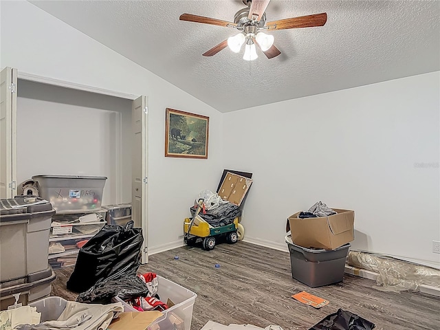 office space featuring ceiling fan, a textured ceiling, baseboards, wood finished floors, and lofted ceiling