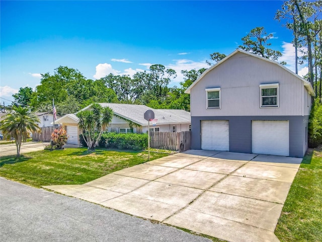 view of front of home with a garage, fence, driveway, and a front lawn