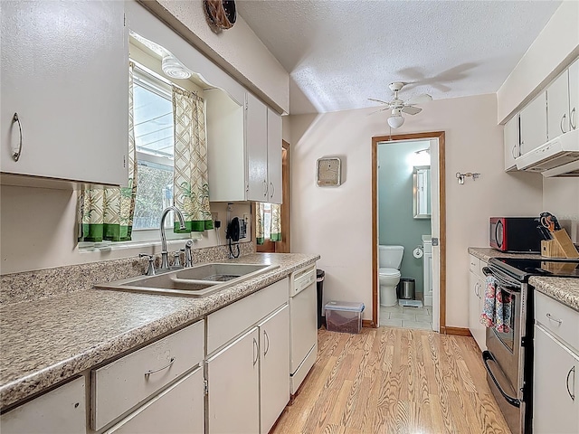 kitchen featuring stainless steel electric range oven, white dishwasher, a sink, light wood-style flooring, and a ceiling fan