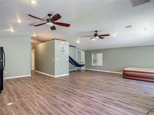 unfurnished living room featuring baseboards, ceiling fan, visible vents, and wood finished floors