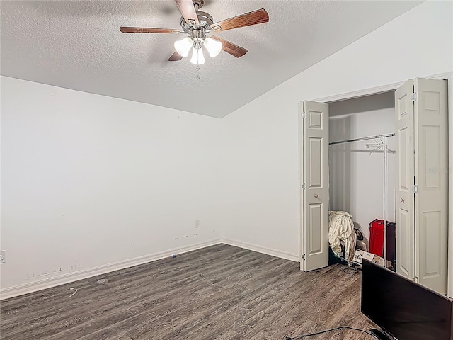 unfurnished bedroom with a textured ceiling, a ceiling fan, lofted ceiling, dark wood-style floors, and a closet
